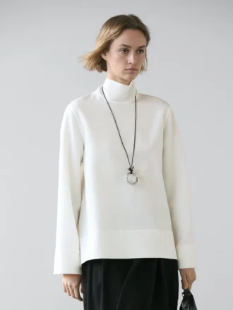 Blus med hög hals och detalj vid fållen