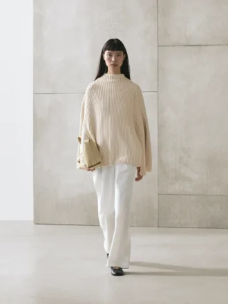 Stickad cape med slitsar